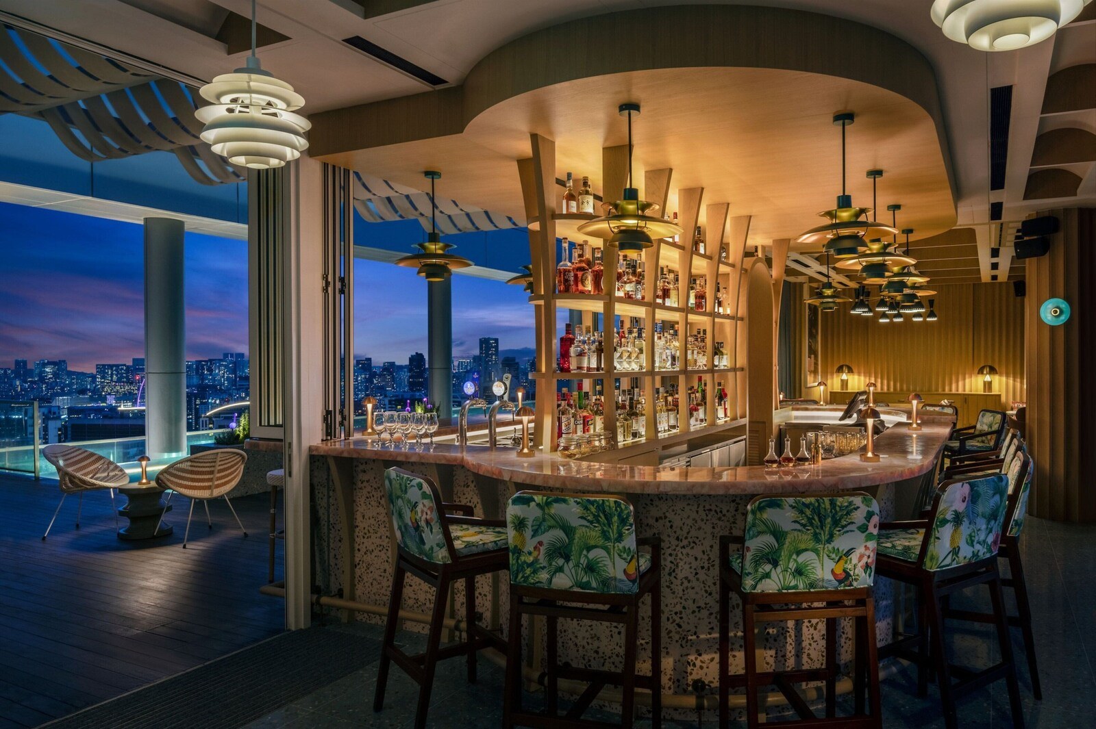 A bar area with a city view, modern lighting, and tropical-themed chairs. - Courtyard by Marriott Singapore Novena (Singapore)